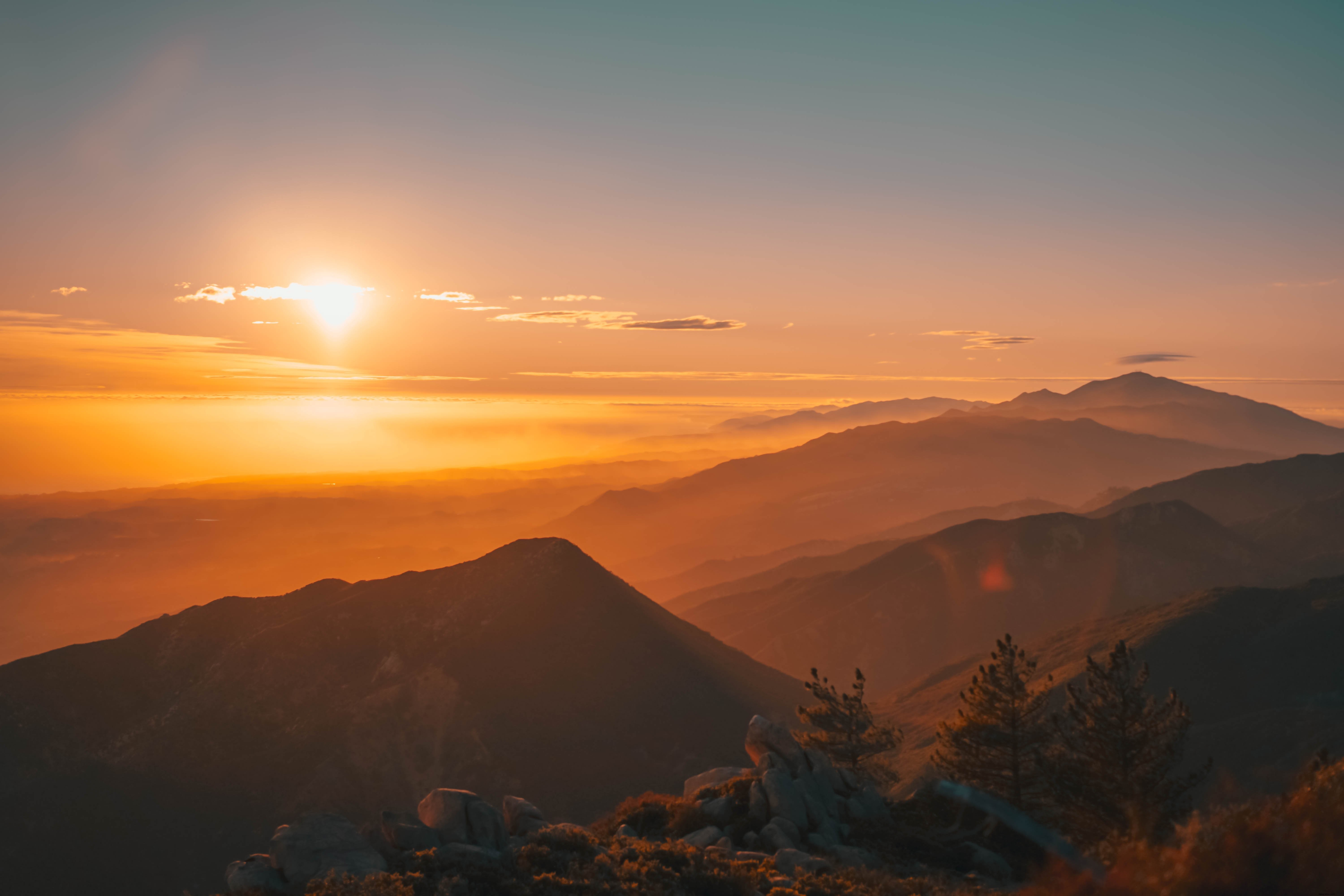 霧に包まれた山々に沈む美しい夕日の写真