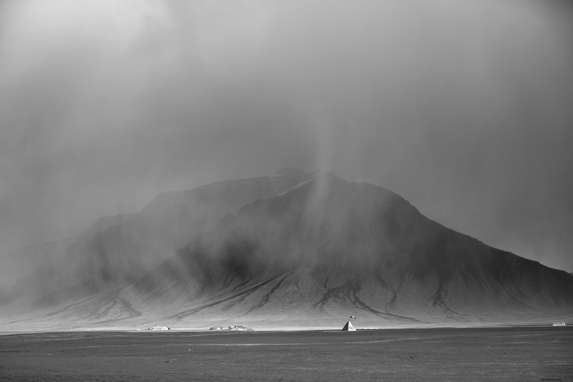 グレースケールの霧に包まれた山の写真