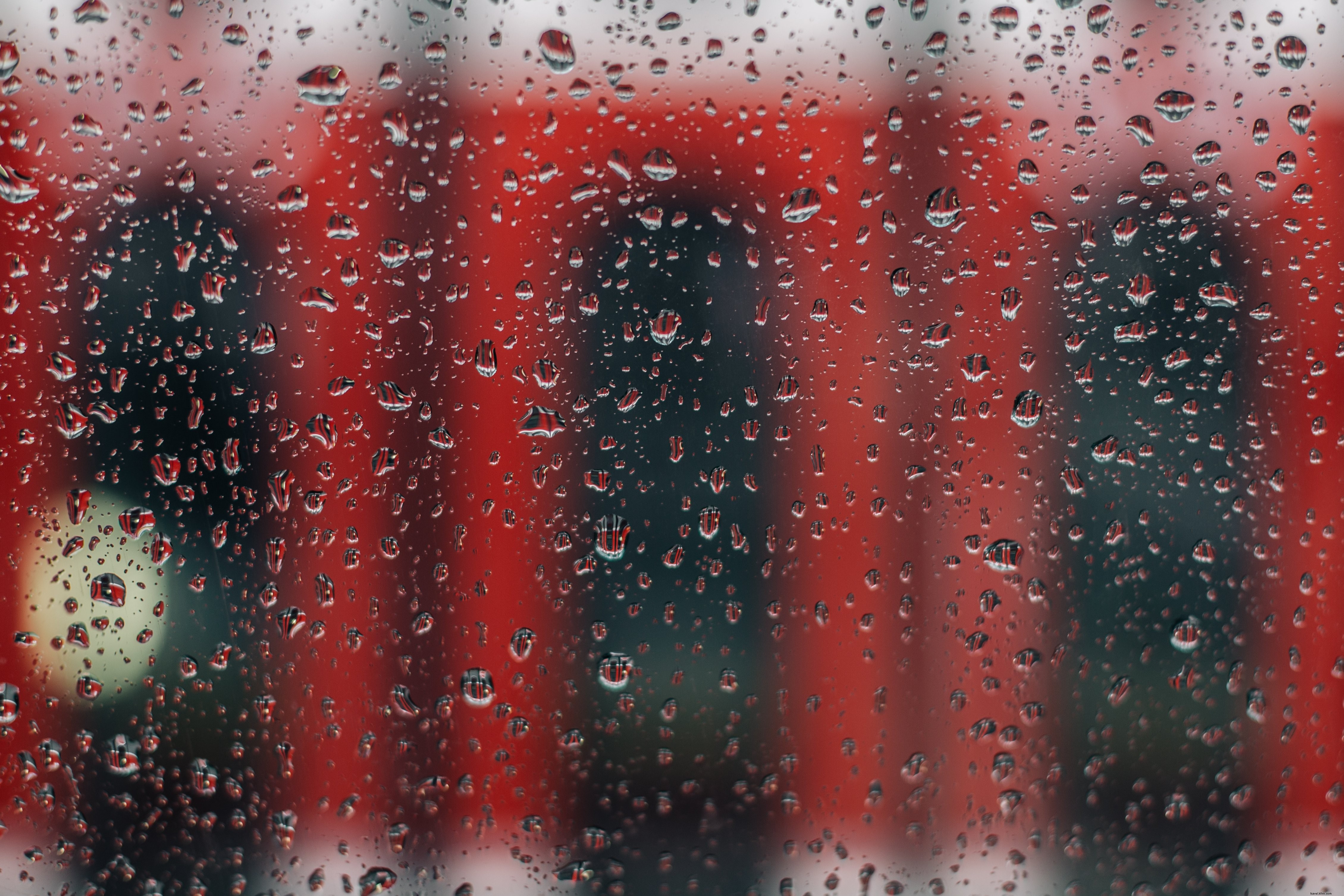 赤い路面電車と雨の窓の写真