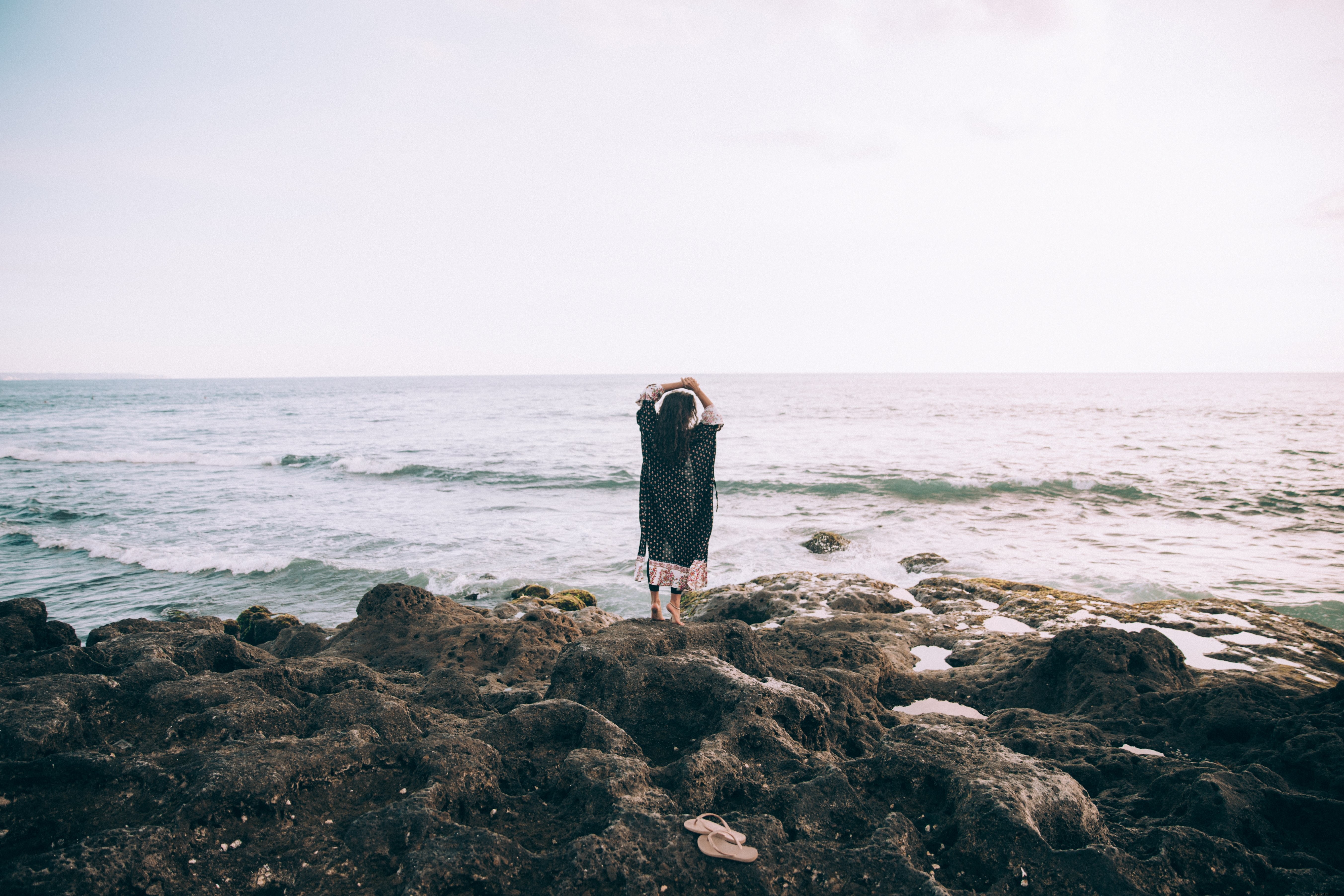 ビーチのそばで女性が幻想的な写真に手を差し伸べる
