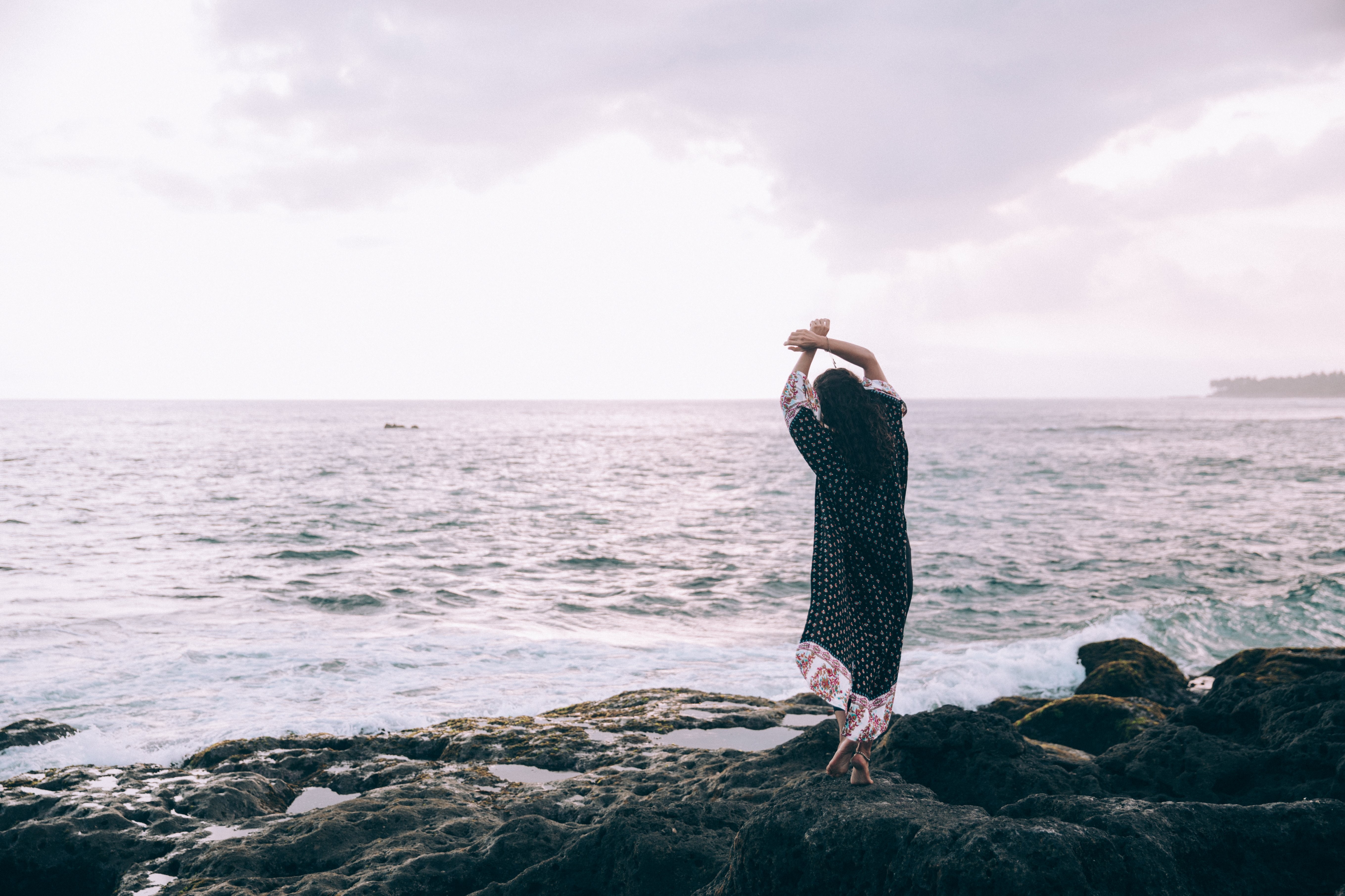 ビーチでローブ姿の女性がポーズをとる写真