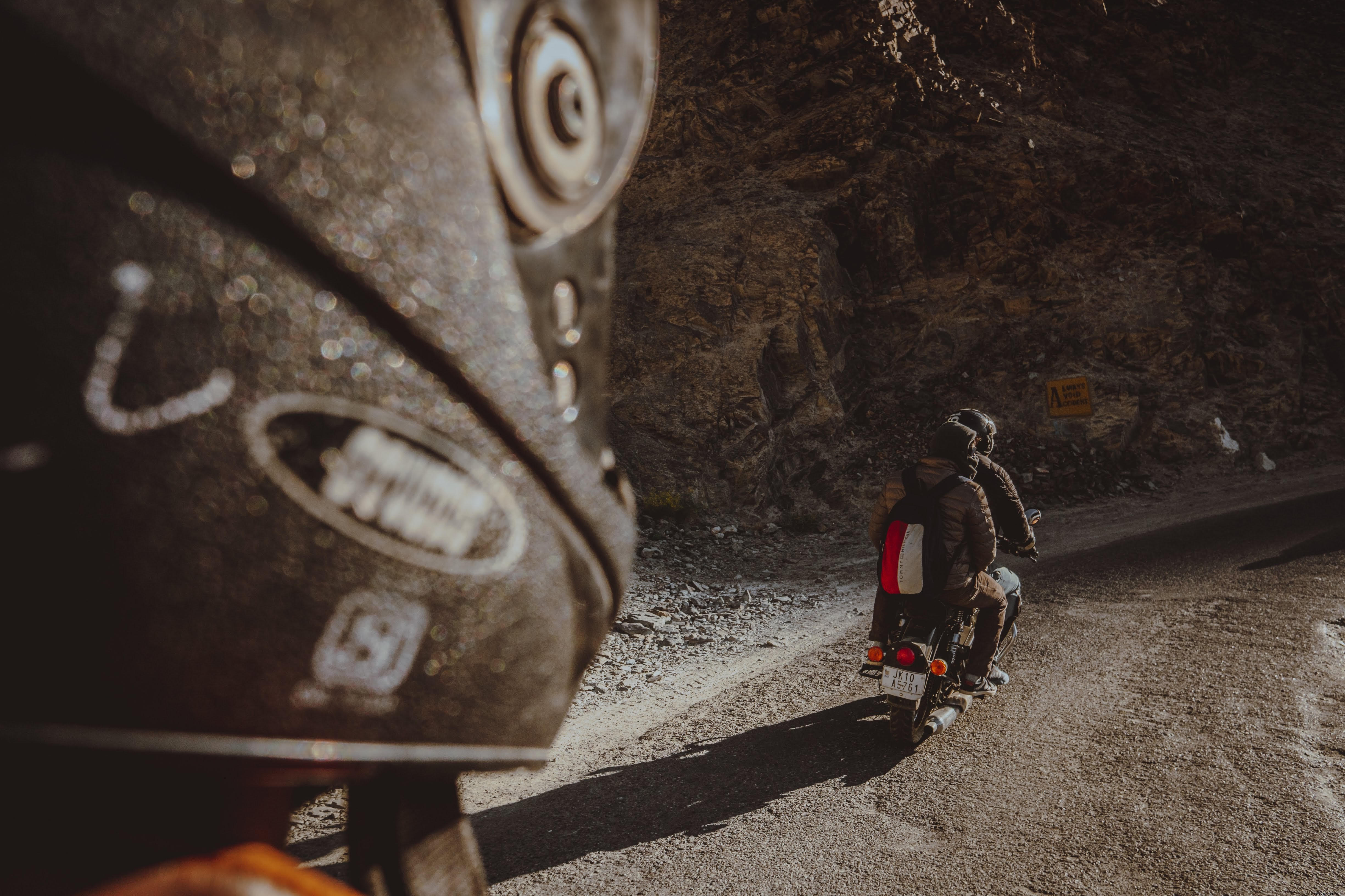 未舗装道路でバイクに乗る二人の姿