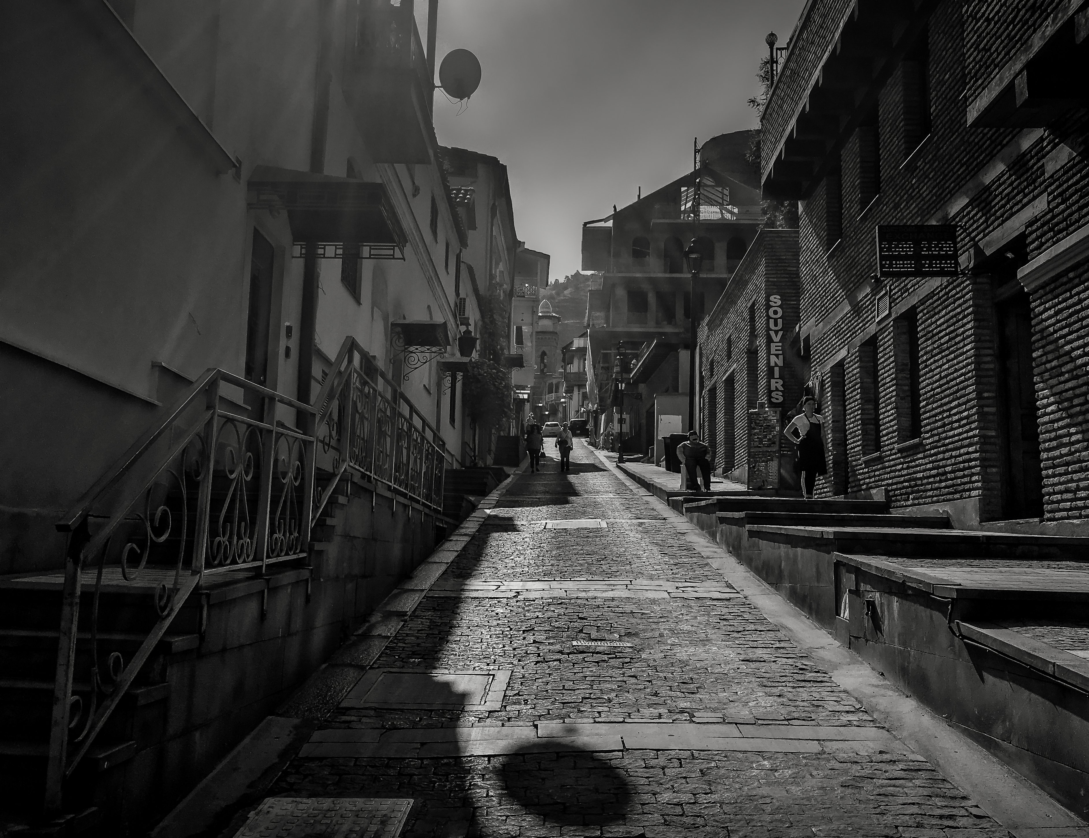 狭い石畳の路地を写したモノクロ写真