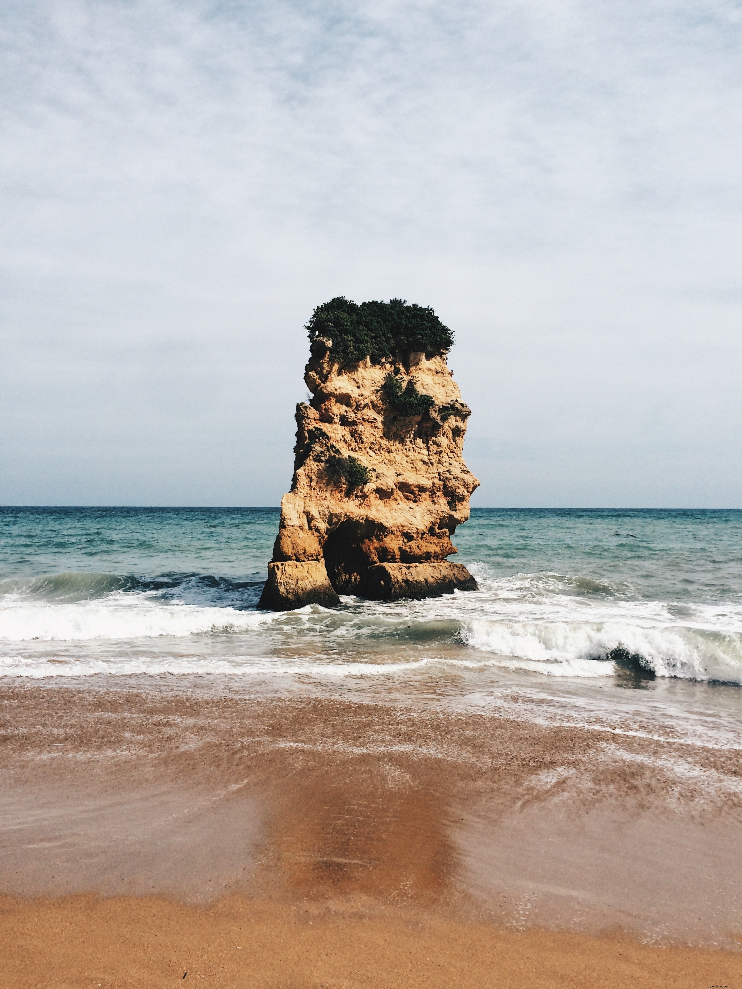 海の真ん中にそびえる大岩の写真