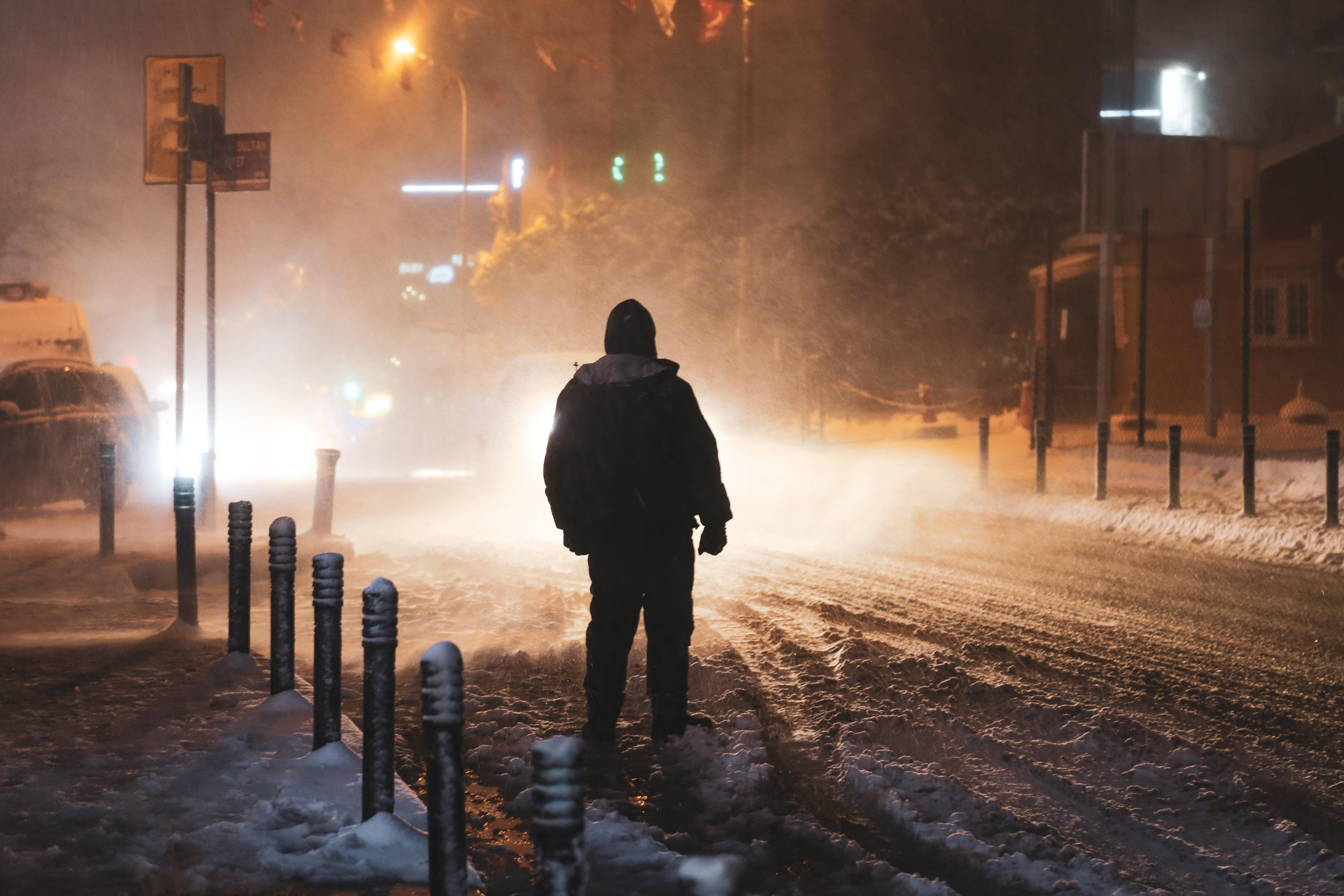 吹雪の中、街灯に照らされた人物